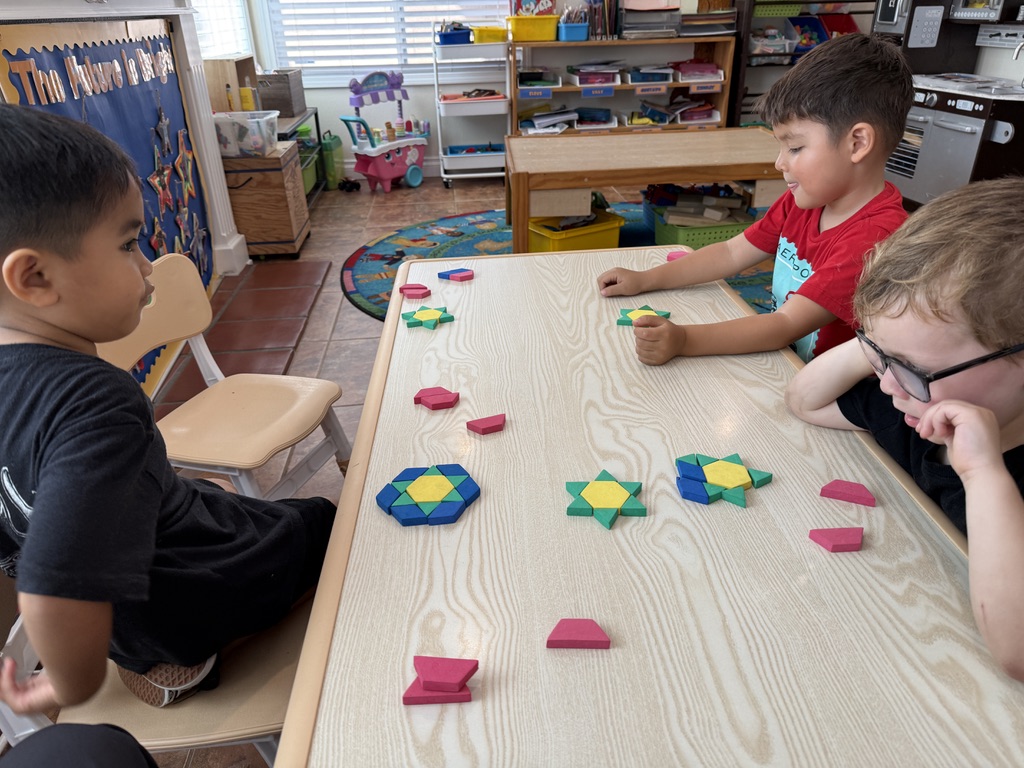 Children building symmetrical designs with pattern blocks