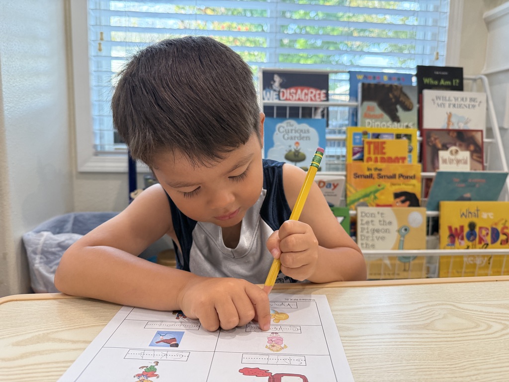 A student working on a phonics page during morning one-on-one time